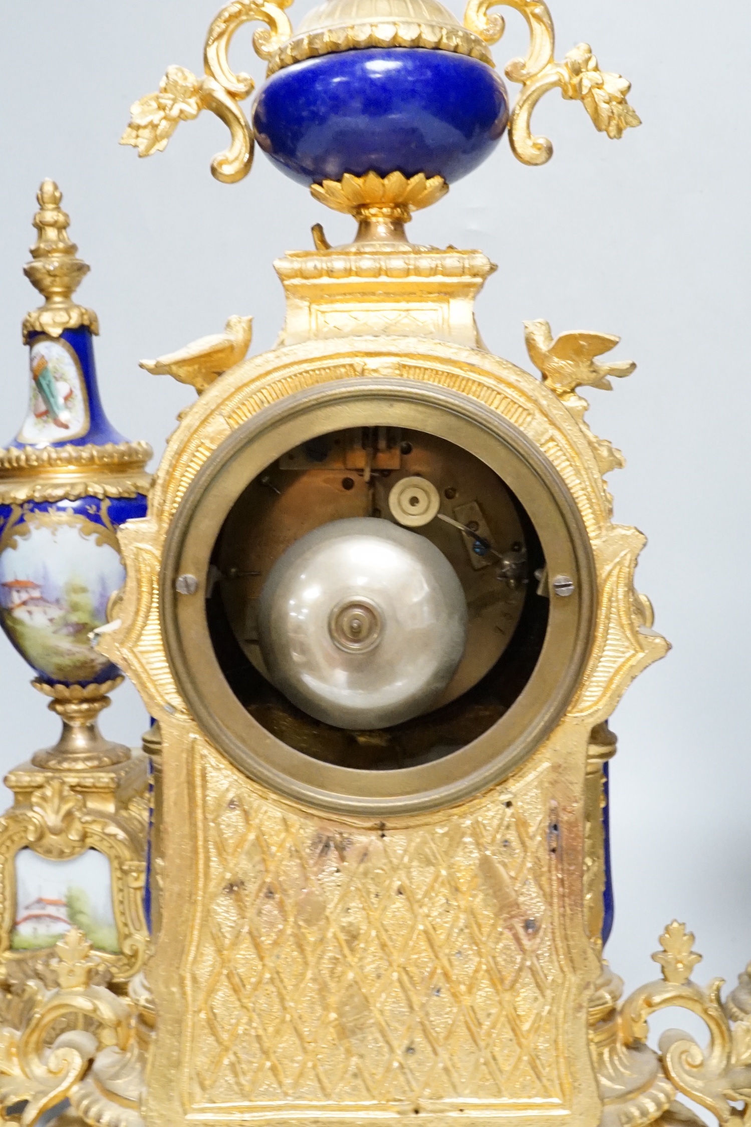 An early 20th century French gilt metal and porcelain set clock garniture, 42cm